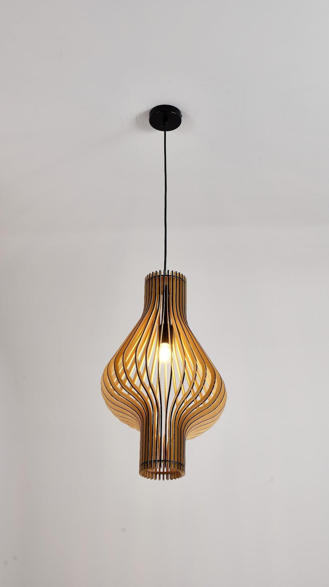 suspension en bois design organique avec lamelles courbées et câble noir, photo studio