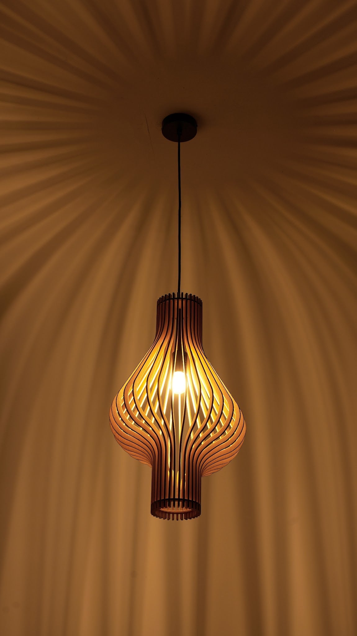 suspension en bois allumée avec lumière chaude et motif de rayons au plafond