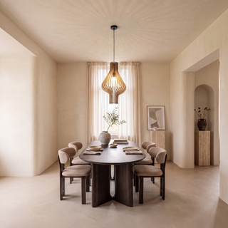suspension en bois au-dessus d'une table ovale sombre dans une salle à manger japandi sereine